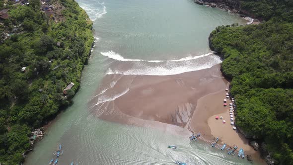 Aerial view of Baron beach in Yogyakarta, Indonesia with lighthouse and traditional boats