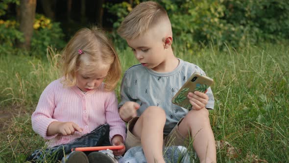 Kids Playing with Smartphones in the Park