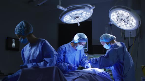 Diverse surgeons wearing surgical caps and face masks in operating theatre in hospital