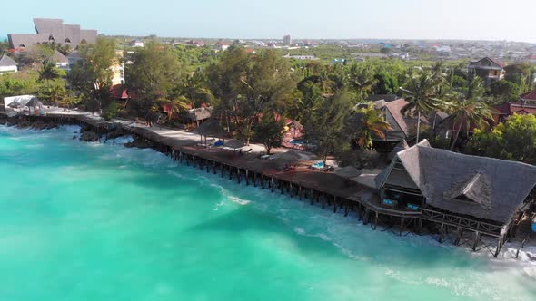 Tropical Landscape of Zanzibar Waves Hit Reef on Hotels Coastline with Palms