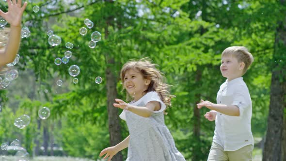 Multi-Ethnic Group of Kids Playing with Soap Bubbles Outdoors