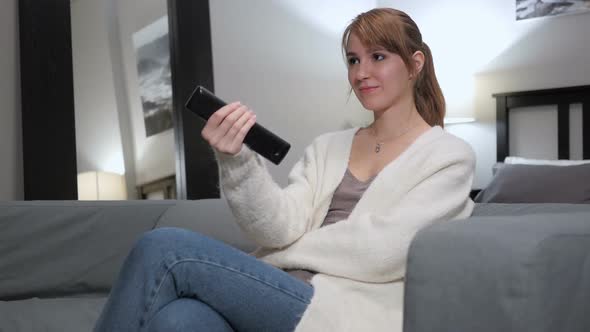 Woman Watching TV Changing Channels with Remote