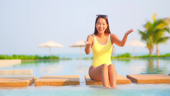 Young asian woman enjoy around outdoor swimming pool for leisure