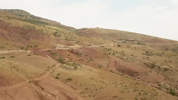 Drone view of trucks driving through the bending roads of a mountain; driving truck in a rugged terr