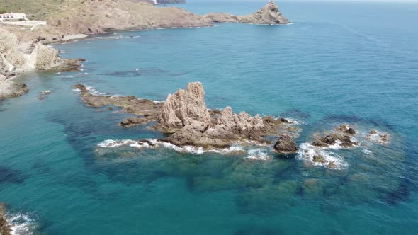 flying around a cliff in the water near the coast