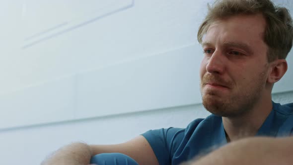 Crying Doctor Sitting Corridor After Bad Day Close Up