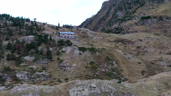 Le Refuge d'Espingo chalet at Lac d'Espingo lake in Haute-Garonne, Pyrénées, France, Aerial orbit ar