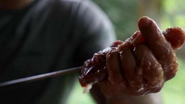 Man is Putting Meat on Skewers for Cooking Kebab and Grill Closeup of Hands