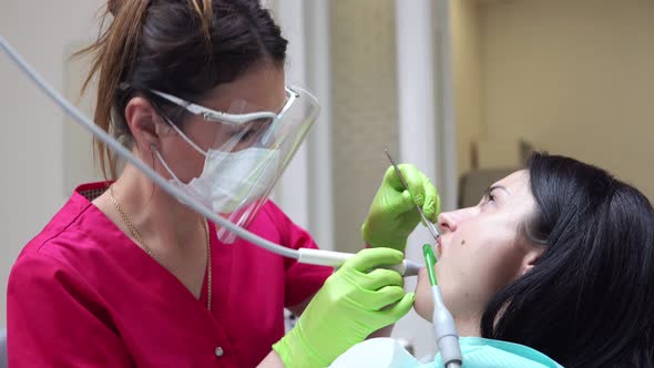 Woman at the Dental Hygienist Getting Professional Tooth Whitening and Ultrasound Cleaning