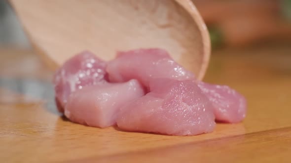 Super Slow Motion Of Uncooked Young Lamb Meat On Chopping Board Pushed By A Wooden Spoon. close up