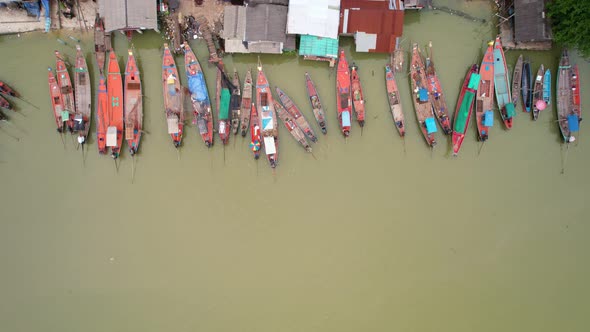 Aerial view top view of the fisherman village with fishing boats and house roof at the pier