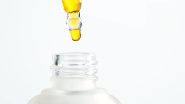 Super Slow Motion Shot of Oily Essence Drop Into Phial Isolated on White Background at 1000Fps