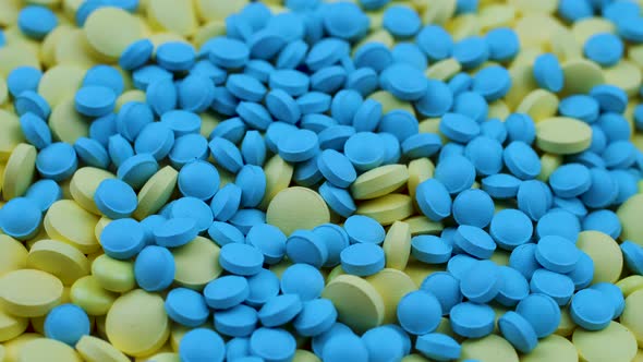 Small Blue Nutritional Supplements Are Scattered on Yellow Antidepressants.