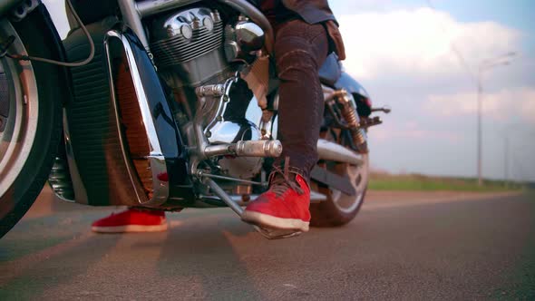 The Biker Turns on the Gear on the Motorcycle Chopper and Starts to Ride