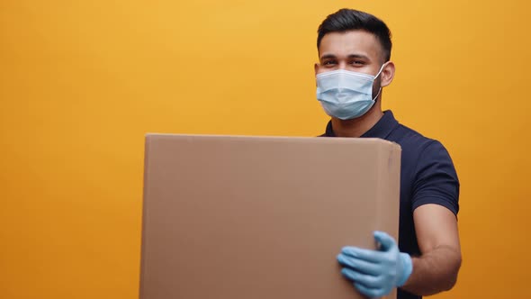 Courier Holding Big Cardboard Box and Nodding His Head