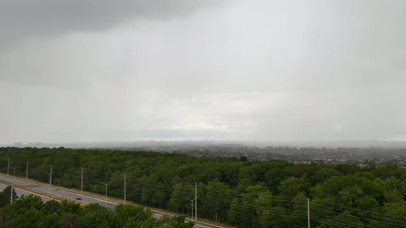 Timelapse sheet rain incoming across saturated monsoon woodland highway road