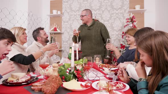 Man Making a Toast at Family Dinner with Champagne