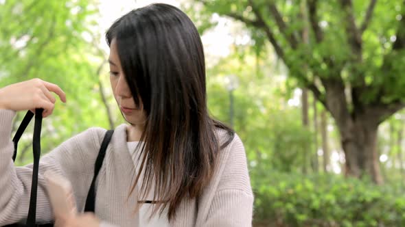 Woman taking out cellphone from bag and talking on mobile phone