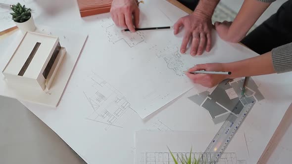 Close Up Hands of Two Workers Discussing Building Drawings in Office, Closeup Shooting of Arms