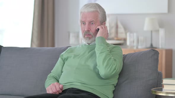 Old Man Talking on Smartphone at Home