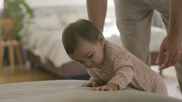 Cute Little Baby in Pajamas Playing in Parents Bed