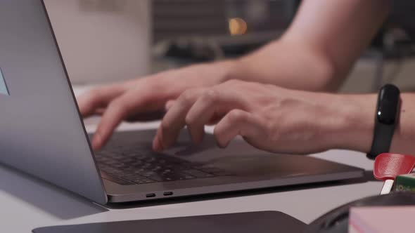 Close up fingers typing on laptop computer keyboard in office