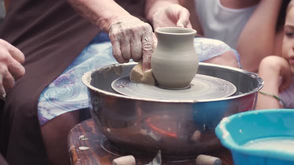 Grandmother with a Grandchildren Make Pitchers in Pottery