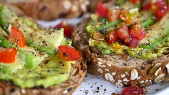 Freshly Avocado Toast with Tomatoes and Black Pepper on Plate