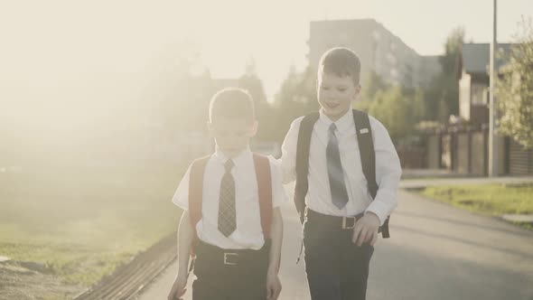 CU, Tracking, Slow Motion: Two Schoolchildren Go Home After School, They Talk, Smile