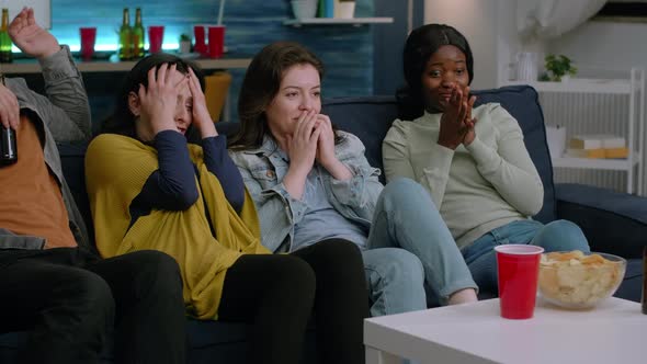 Group of Multiethnic Watching at Terrifying Movie on Television