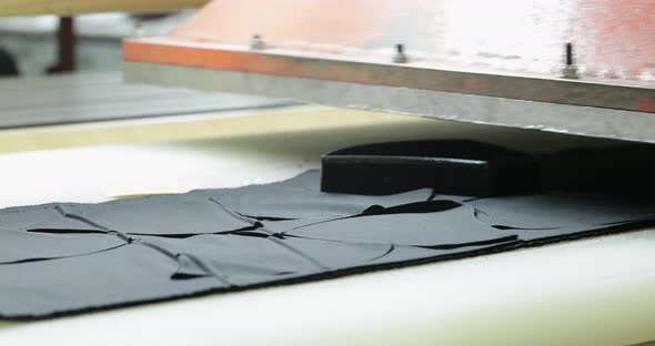 A Sew Factory Worker Placing A Small Metal Tool Making Face Mask Patterns On Fabric Pressing It Usin