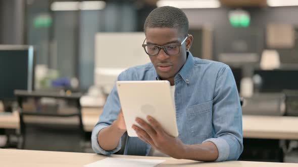 Young African American Man Having Loss on Tablet in Office