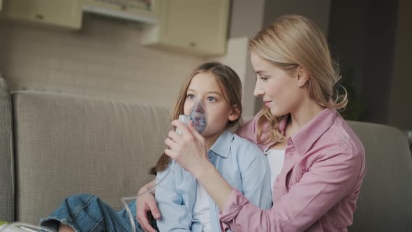 Mother is Helping Her Little Daughter with Breathing with Help of Nebulizer Which is Treating