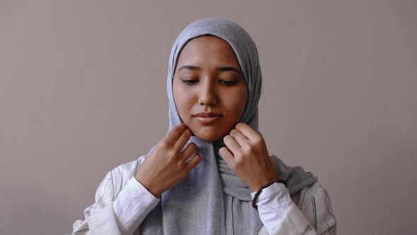 Muslim Girl Adjusting Her Hijab and Smiling at the Camera