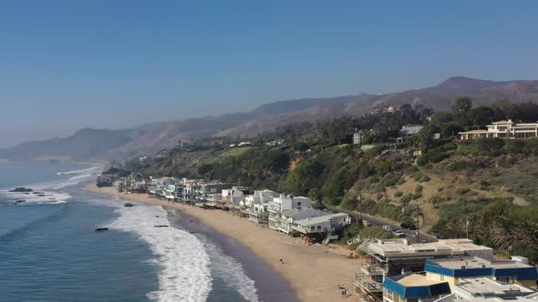 Cinematic aerial shot of famous Carbon Beach in Malibu with real estate in California, United States