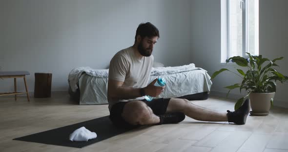 Tired Man Drinking Water From Bottle After Working Out