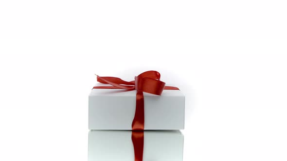 Beautiful White Gift Box with Red Bow Rotating Isolated on White Background