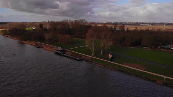 View Of Arborists Getting Ready To Cut Tree Beside Oude Maas On Grass In Barendrecht. Aerial Pedesta