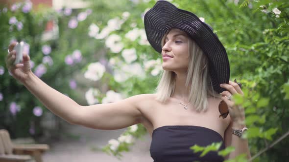 Young Stylish Beautiful Woman in Hat Does Selfie