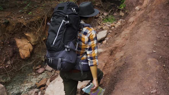 slow-motion of man traveler with backpack walking and looking in the natural forest