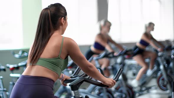 Athletic Woman Riding on Exercise Bike During Cycling Class