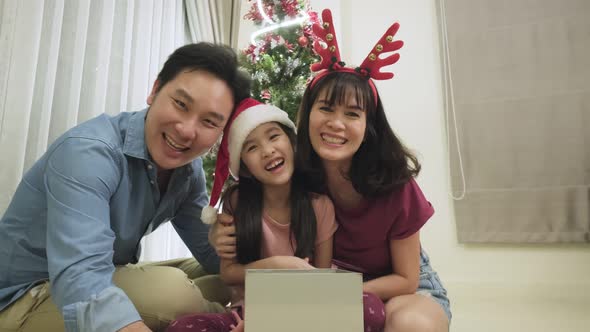 Asian young parents with little child open xmas present box with happiness then looking camera.