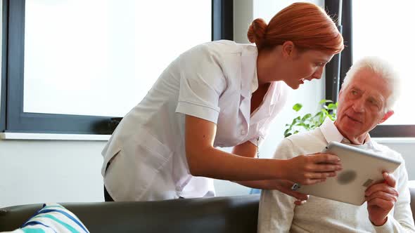 Nurse and senior patient using tablet computer