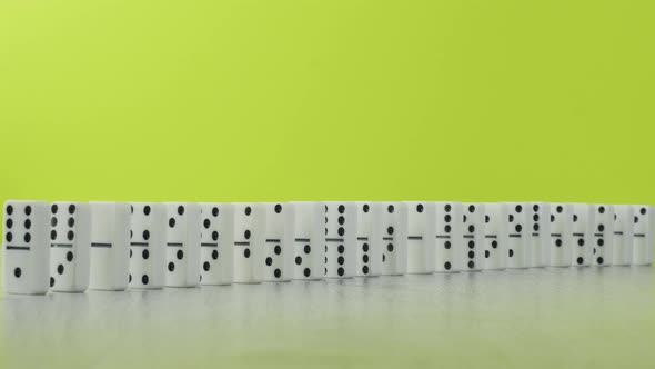 Domino Effect - a Series of White Dominoes Falling Down the Chain Colorful Background