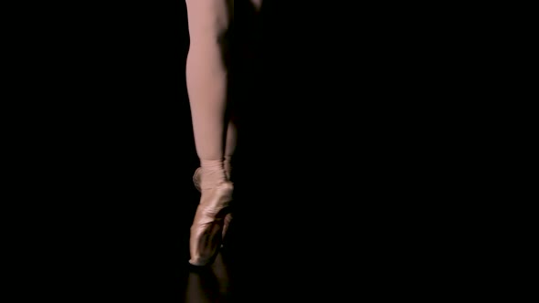 Graceful Legs of a Ballerina in White Pointe Shoes. Ballerina Shows Classic Ballet Pas. Shot in a