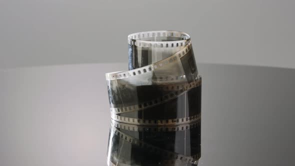 35mm film negative rotating on a reflective surface. Studio shot