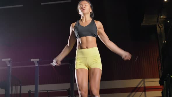 Woman Jumps Rope Actively Warming Up in Large Gym Hall
