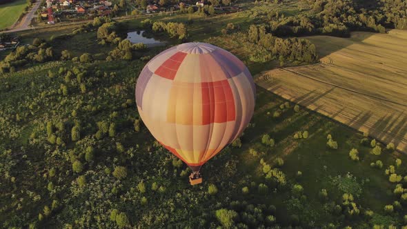 Large Hot Air Balloon Flies Over Green Forest Near Town