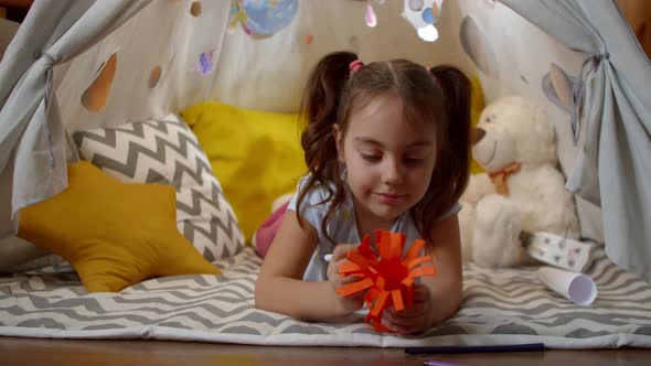 Little Girl Plays Space Aliens at Home Sitting in a Tent