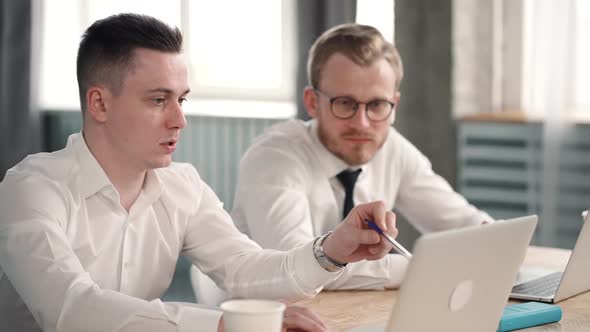 Businesspeople Man Talk Collaborating Using Laptop Computers in Office. Two Males Corporate